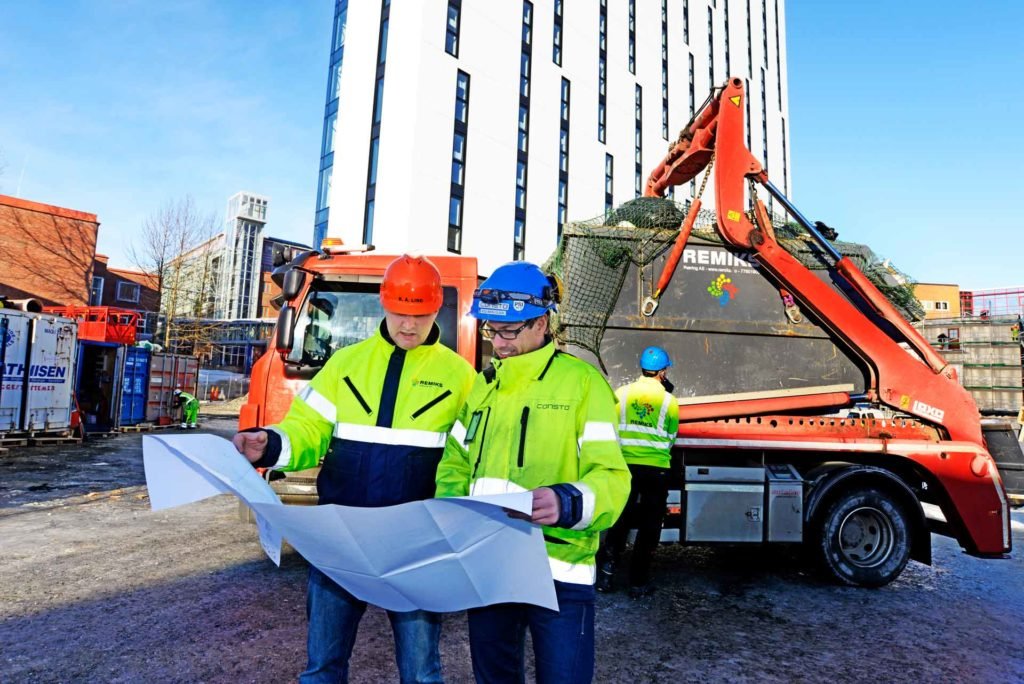 to personer studerer en plantegning på anleggsområde