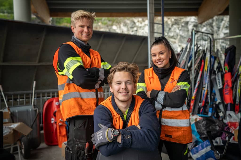 Tre stolte medarbeidere i Remiks smiler